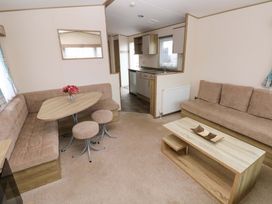 A living room with a table and chairs at 82 Manorbier Park in Manorbier