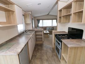 A kitchen with sink, stove, and refrigerator at 82 Manorbier Park in Manorbier