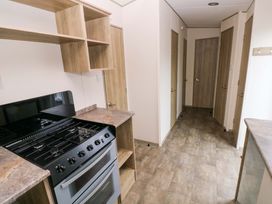 A kitchen with an oven and shelves at 82 Manorbier Park in Manorbier