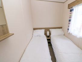 A bedroom with two single beds and a nightstand at 82 Manorbier Park in Manorbier