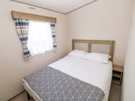 A bedroom with a double bed and window at 82 Manorbier Park, Manorbier