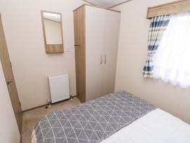 A bedroom with a bed and wardrobe at 82 Manorbier Park in Manorbier