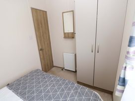 A bedroom with a bed, wardrobe, and door at 82 Manorbier Park in Manorbier