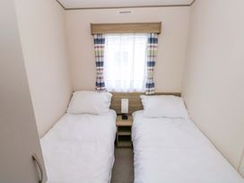 A bedroom with two single beds and a nightstand at 82 Manorbier Park in Manorbier
