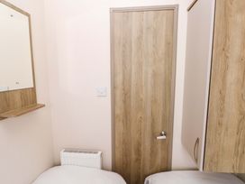 A bedroom with a mirror and door at 82 Manorbier Park in Manorbier