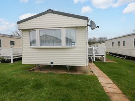 A caravan with a satellite dish and a pathway at 82 Manorbier Park in Manorbier