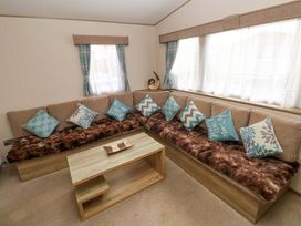 A living room with a sofa and coffee table at 82 Manorbier Park in Manorbier