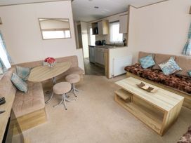 A living room with a dining table and sofa at 82 Manorbier Park in Manorbier