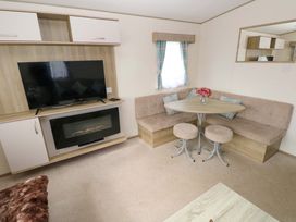A living room with a TV and sofa at 82 Manorbier Park in Manorbier