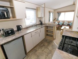 A kitchen with appliances and seating area at 82 Manorbier Park in Manorbier