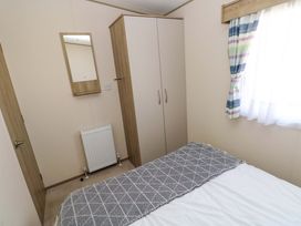 A bedroom with a bed and wardrobe at 82 Manorbier Park in Manorbier