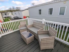 An outdoor seating area with a couch, chairs, and a table at 82 Manorbier Park, Manorbier