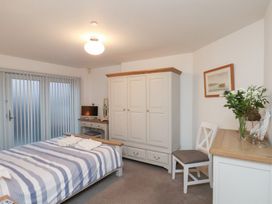 A bedroom with a bed and wardrobe at One Union Mill - garden apartment Whitby