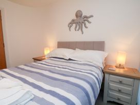 A bedroom with a bed and bedside tables at One Union Mill - garden apartment Whitby