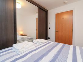 A bedroom with a bed and wardrobe at One Union Mill - garden apartment in Whitby