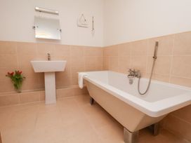 A bathroom with a bathtub and sink at One Union Mill - garden apartment in Whitby