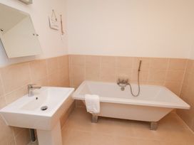 A bathroom with a bath tub and sink at One Union Mill - garden apartment in Whitby