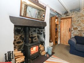 A living room with a fireplace and wooden door at Parc y Brenin Holidays, Abersoch