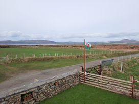 A view of a grassy field with a flag and gate at Parc y Brenin Holidays, Abersoch Cilan near Abersoch