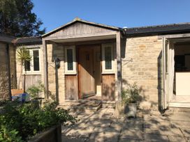 An entrance with a wooden door and stone walls at Meadow Lodge, Cerney Wick near South Cerney, Cotswolds