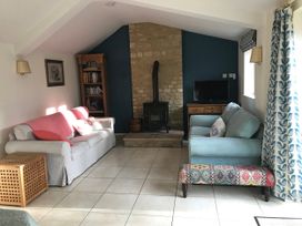 A living room with a sofa, fireplace and bookshelf at Meadow Lodge in Cerney Wick near South Cerney, Cotswolds