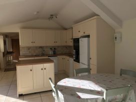 A kitchen with wooden cabinets and a table at Meadow Lodge in Cerney Wick near South Cerney, Cotswolds