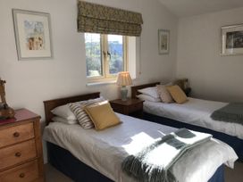 A bedroom with two beds and a lamp at Meadow Lodge, Cerney Wick near South Cerney, Cotswolds