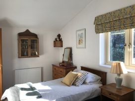 A bedroom with a bed and furniture at Meadow Lodge, Cerney Wick near South Cerney, Cotswolds