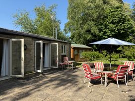 An outdoor seating area with chairs and a table at Meadow Lodge Cerney Wick near South Cerney Cotswolds