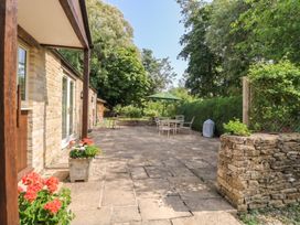 A patio area with a table and chairs at Meadow Lodge in Cerney Wick near South Cerney, Cotswolds