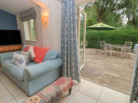 A living room with a sofa and television at Meadow Lodge in Cerney Wick near South Cerney, Cotswolds