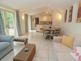 A living room with a sofa and dining area at Meadow Lodge in Cerney Wick near South Cerney, Cotswolds