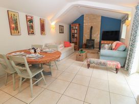 A living room with a dining area and a sofa at Meadow Lodge in Cerney Wick near South Cerney, Cotswolds