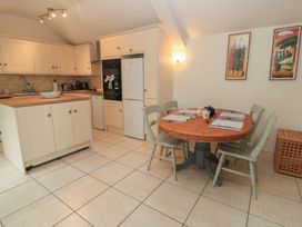 A kitchen with a round table and chairs at Meadow Lodge Cerney Wick near South Cerney Cotswolds