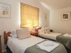 A bedroom with two beds and a lamp at Meadow Lodge in Cerney Wick near South Cerney, Cotswolds