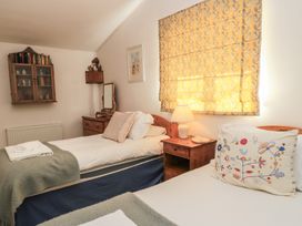 A bedroom with two beds and a lamp at Meadow Lodge, Cerney Wick near South Cerney, Cotswolds