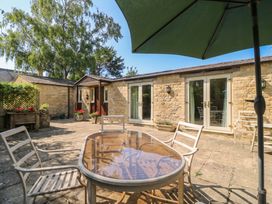 An outdoor dining area with a table and chairs at Meadow Lodge in Cerney Wick near South Cerney, Cotswolds
