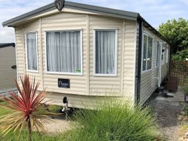 A mobile home with a sign on the side and plants at Swanage Bay View in Swanage