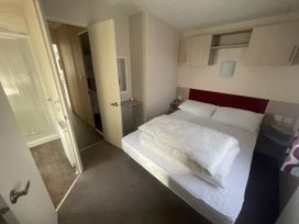 A bedroom with a bed and attached shower at Swanage Bay View in Swanage