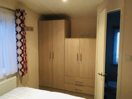 A bedroom with wardrobe and bed at Swanage Bay View, Swanage
