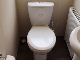 A bathroom with a toilet and a radiator at Swanage Bay View in Swanage