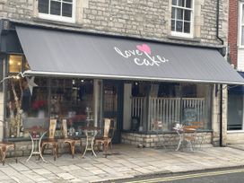 An outdoor cafe with tables and chairs at Swanage Bay View in Swanage
