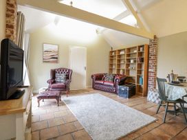 A living room with a television and sofas at Ivy Barn in Norwich