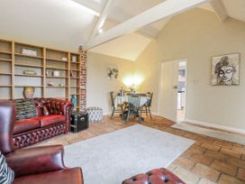 A living room with a sofa and dining table at Ivy Barn in Norwich