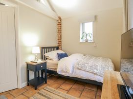 A bedroom with a bed and nightstand at Ivy Barn in Norwich