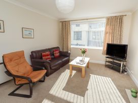 A living room with a sofa and coffee table at Kittiwake at No 20 Seahouses