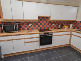 A kitchen with cabinets and appliances at Kittiwake at No 20 Seahouses