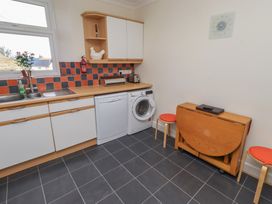 A kitchen with appliances and furniture at Kittiwake at No 20 Seahouses