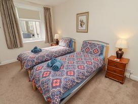 A bedroom with twin beds and a nightstand at Kittiwake at No 20 Seahouses