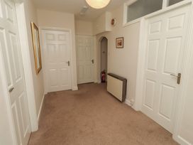 A hallway with multiple doors and a mirror at Kittiwake at No 20 Seahouses